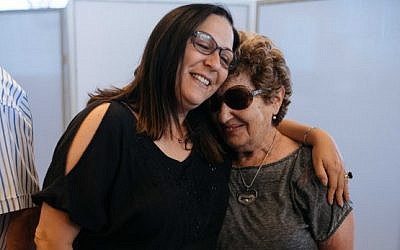 Survivors of Operation Thunderbolt, the Israeli rescue of over 100 hostages from the Entebbe Airport in Uganda on July 4, 1976, hug during an event at the Peres Center for Peace in Jaffa marking 40 years since the kidnapping, on June 27, 2016. (Ben Kelmer/FLASH90)