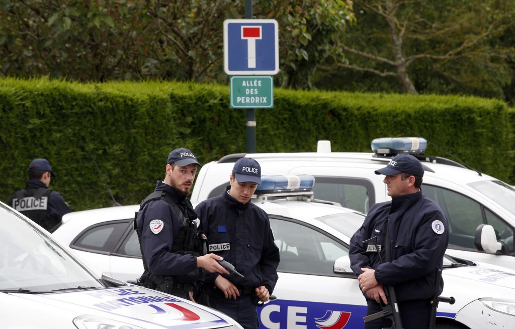 French police officers block the road leading to a crime scene the day after a knife-wielding attacker stabbed a senior police officer to death Monday evening outside his home in Magnanville, west of Paris, France, Tuesday, June 14, 2016. (AP Photo/Thibault Camus)