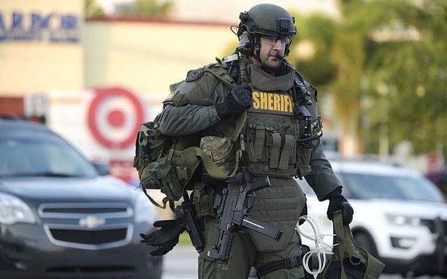 An Orange County Sheriff's Department SWAT member arrives to the scene of a fatal shooting at Pulse Orlando nightclub in Orlando, Fla., Sunday, June 12, 2016. (AP Photo/Phelan M. Ebenhack)