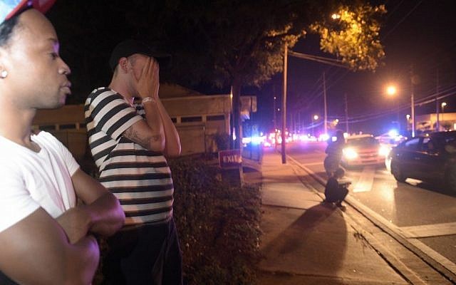 Jermaine Towns, left, and Brandon Shuford wait down the street from a multiple shooting at a nightclub in Orlando, Fla., Sunday, June 12, 2016. (AP Photo/Phelan M. Ebenhack) 
