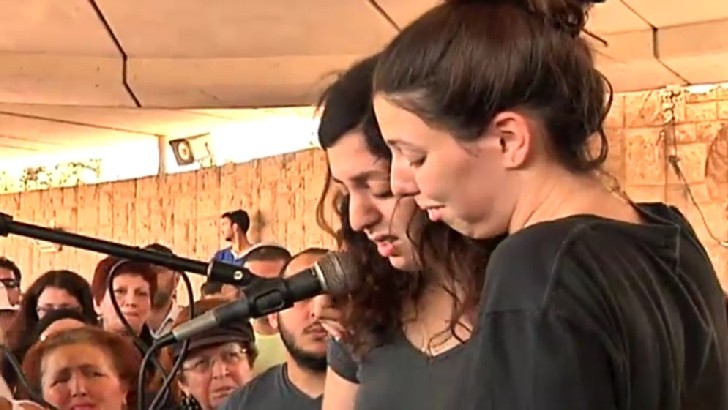 The daughters of Ilana Naveh, one of the four victims of the Sarona Market attack in central Tel Aviv on June 8, 2016, speak at her funeral in Petah Tikva on June 10, 2016. (Screenshot/Channel 2)