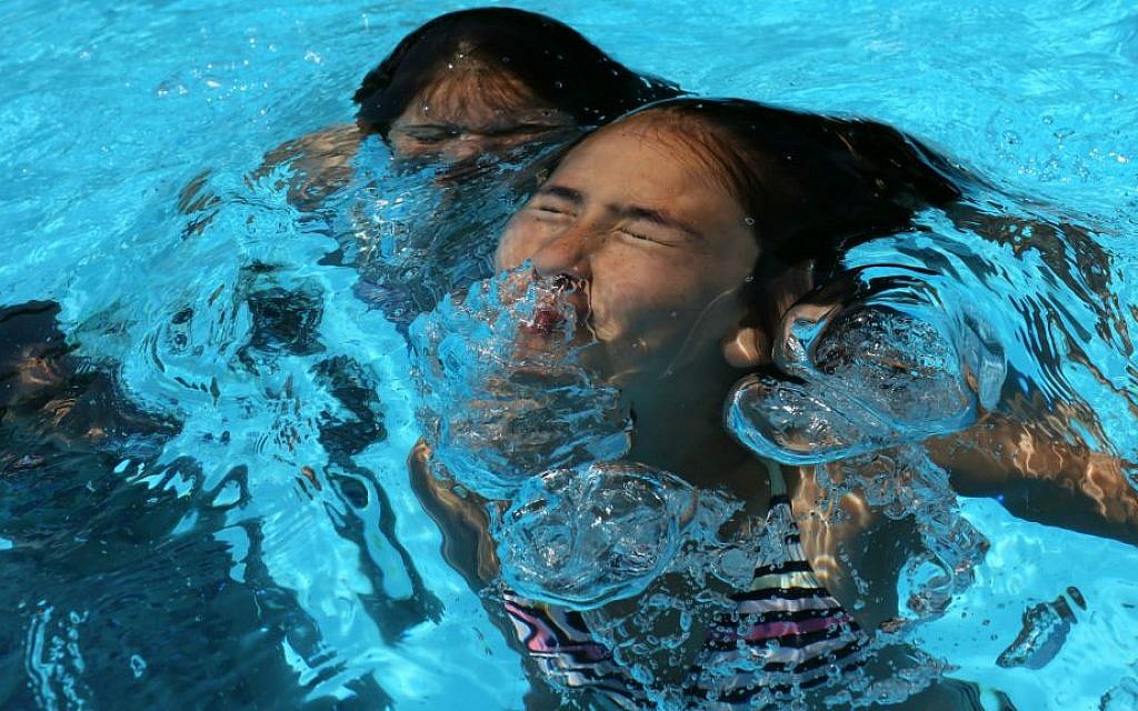 Illustrative photo of young girls playing in a swimming pool. (Nati Shohat/Flash90)