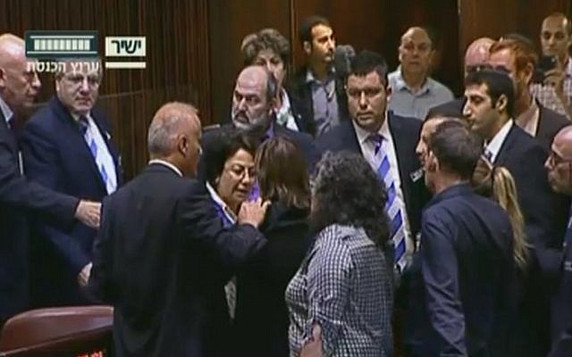 Joint (Arab) List MK Hanin Zoabi, center, confronted by fellow lawmakers in the Knesset plenum over her comments on the Israel-Turkey reconciliation agreement on June 29, 2016 (screen capture: Knesset Channel)