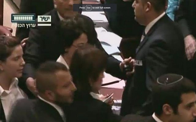 Joint (Arab) List MK Hanin Zoabi is led out of the Knesset plenum after a row over her comments on the Israel-Turkey reconciliation agreement on June 29, 2016 (screen capture: Knesset Channel)