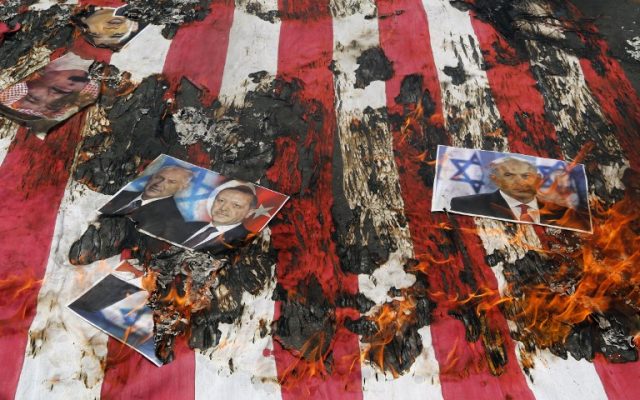 Portraits of Bahraini King Hamad (top L), Israeli Minister Benjamin Netanyahu and Turkish President Recep Tayyip Erdogan lie on a US flag in flames during a parade marking al-Quds (Jerusalem) Day in Tehran on July 1, 2016. (Atta Kenare/AFP)