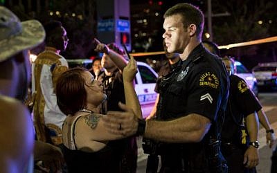 Police attempt to calm the crowd as someone is arrested following the sniper shooting in Dallas on July 7, 2016. (AFP PHOTO / Laura Buckman)