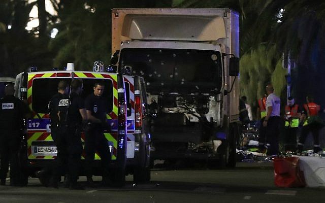 Police officers and rescue workers stand near a van that plowed into a crowd leaving a fireworks display in the French Riviera town of Nice on July 14, 2016. (Valery Hache/AFP)