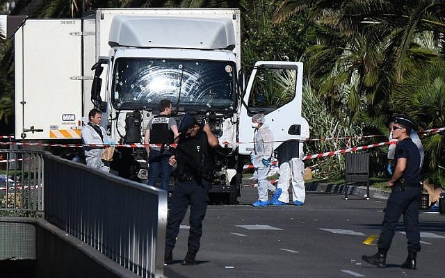 Forensics officers and policemen look for evidence in a truck on the Promenade des Anglais in the French Riviera town of Nice on July 15, 2016, after the truck plowed through a crowd watching a fireworks display. (AFP/Anne-Christine Poujoulat)