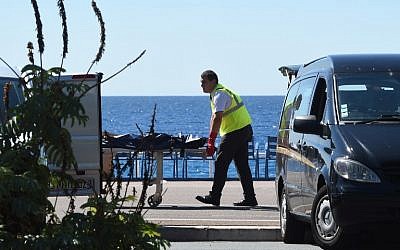 A forensic expert evacuates a dead body on the Promenade des Anglais seafront in the French Riviera city of Nice on July 15, 2016, after a gunman smashed a truck into a crowd of revellers celebrating Bastille Day, killing at least 84 people. (AFP Photo/Boris Horvat)
