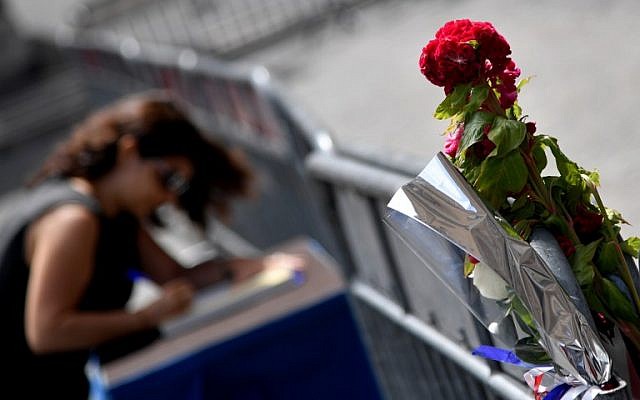 A woman signs the book of condolences in front of the French embassy in Rome on July 15, 2016, after the deadly attacks in Nice. (AFP PHOTO / TIZIANA FABI)