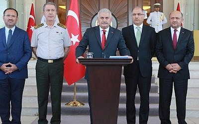 Turkish Prime Minister Binali Yildirim (C), flanked by Turkish Justice Minister Bekir Bozdag (L), Chief of the General Staff of the Turkish Armed Forces Hulusi Akar (2nd L), Turkish Interior Minister Efkan Ala (2nd R) and Turkish Defence Minister Fikri Isik (R), gives a press conference outside the Cankaya Palace in Ankara, on July 16, 2016. (AFP PHOTO/ADEM ALTAN)