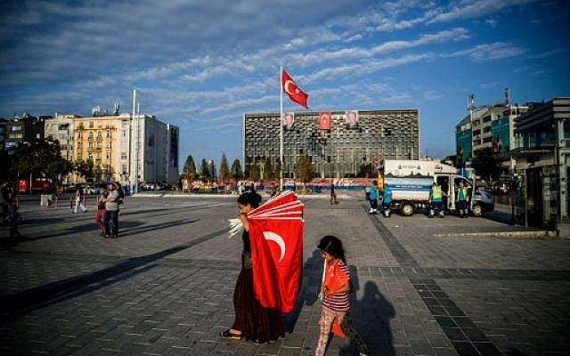 A woman prepares to sell Turkish flags in Taksim square on July 18, 2016 in Istanbul. (AFP PHOTO / OZAN KOSE)