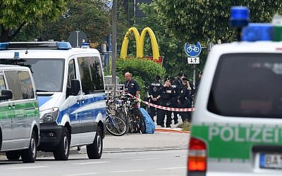Police officers secure the area around a McDonald's restaurant near the shopping mall Olympia Einkaufzentrum OEZ in Munich on July 23, 2016, a day after a gunman went on a shooting rampage, killing nine people in a suspected terror attack. (AFP PHOTO/Christof Stache)