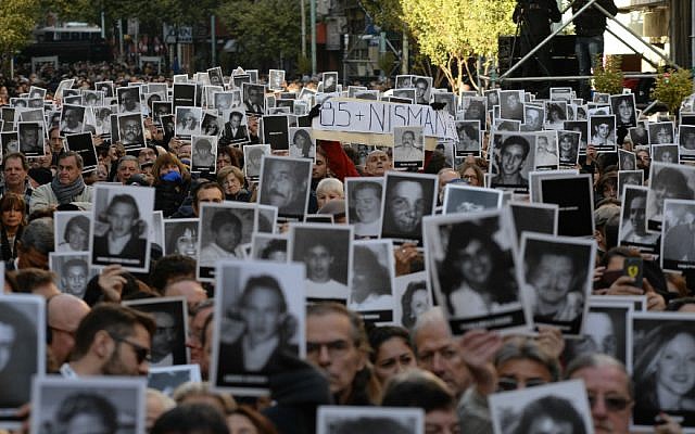 Participants hold photos of some of the 85 victims at a memorial ceremony on the 22nd anniversary of the AMIA Jewish center bombing in Buenos Aires on July 18, 2016. (Photo by Leonardo Kremenchuzky, courtesy of AMIA/Via JTA)