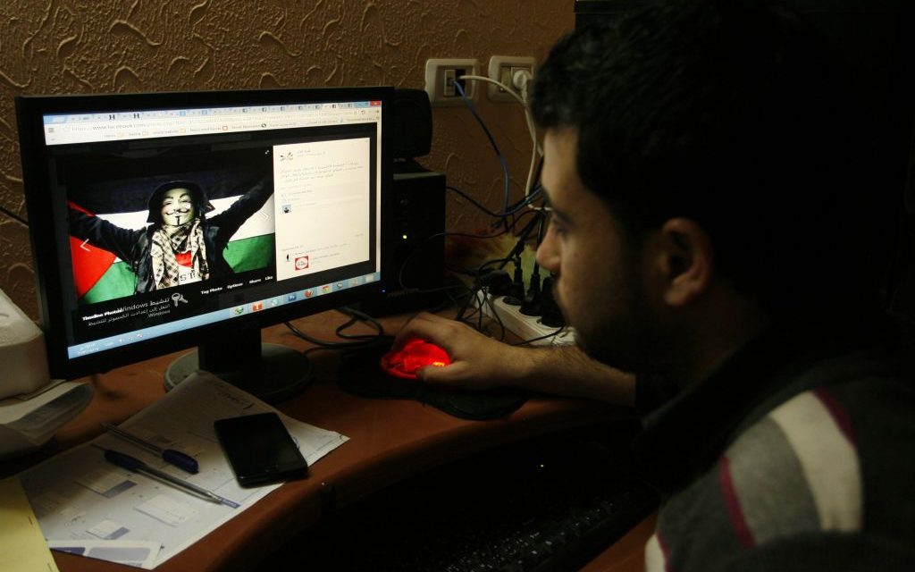 Illustrative: A Gazan man looking at a pro-Palestinian post on Facebook on April 7, 2013. (Abed Rahim Khatib / Flash90)