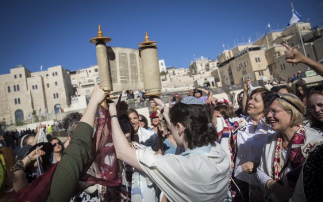 Members of the Women of the Wall hold a Rosh Hodesh (New Jewish month) prayer with a Torah Scroll they snuck in at the Western Wall, in Jerusalem's Old City, on July 7, 2016 (Hadas Parush/Flash90)