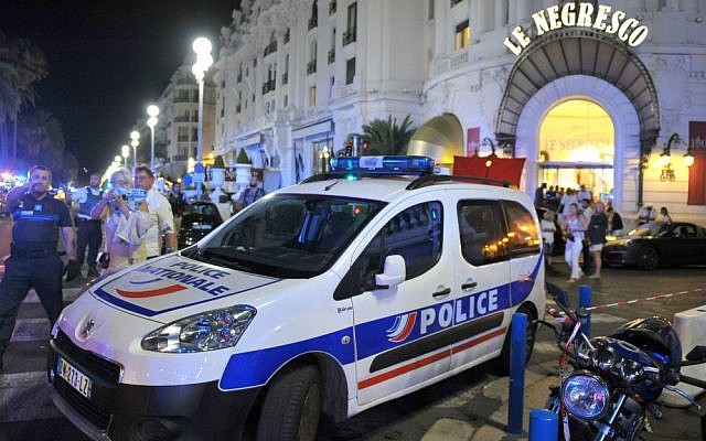 A police car is parked near the scene of a terror attack after a truck drove on to the sidewalk and plowed through a crowd of revelers who'd gathered to watch the fireworks in the French resort city of Nice, southern France, Friday, July 15, 2016. (AP Photo/Christian Alminana)
