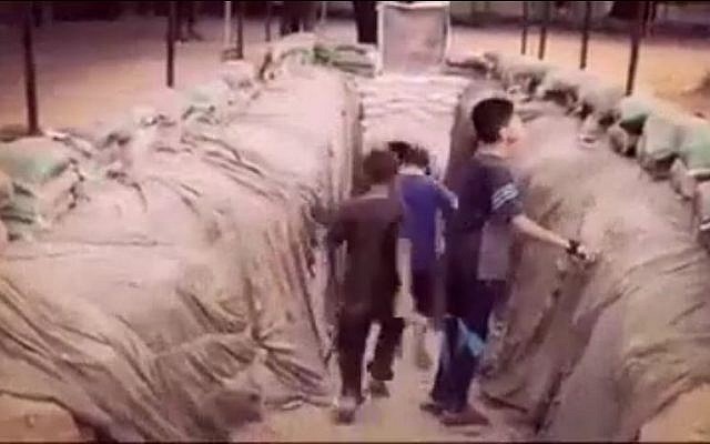 An image taken from a video on Hamas's Facebook page on July 20, 2016, shows Palestinian children entering into a tunnel dug by the terror group in the Gaza Strip. (Screen capture from Facebook)