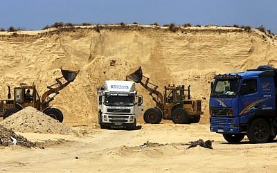 Palestinian diggers dump sand into a truck at the site of Al-Isra 2 housing project in Khan Younis, Gaza Strip, July 20, 2016 (AP Photo/Adel Hana)