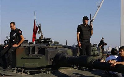 Turkish police officers, loyal to the government, stand atop tanks abandoned by Turkish army officers, near Istanbul's iconic Bosporus Bridge on Saturday, July 16, 2016, following a military failed coup. (AP Photo/Emrah Gurel) 