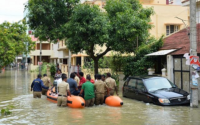 Members of the fire forces and volunteers participate in relief operations in a low-lying flooded area of Bangalore, India, July 29, 2016. (AFP/MANJUNATH KIRAN)