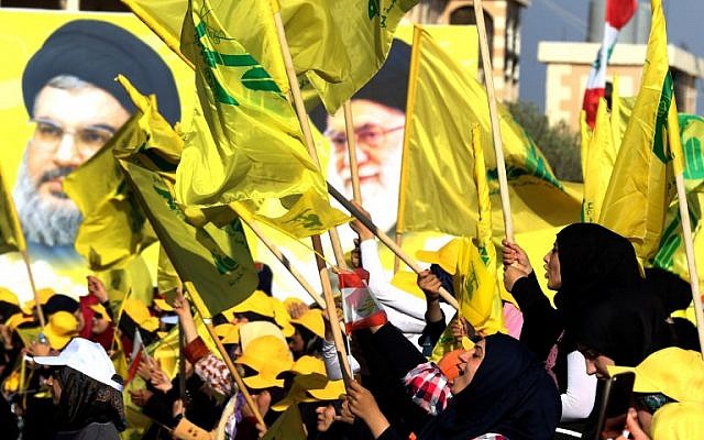 Women wave a Lebanese national flag and Hezbollah flags in front of portraits of Iran's supreme leader Ayatollah Ali Khamenei (R) and Hezbollah leader Hassan Nasrallah, in the southern Lebanese town of Bint Jbeil on August 13, 2016, during a commemoration marking the tenth anniversary of the end of the war between Hezbollah and Israel. (AFP Photo/Mahmoud Zayyat)