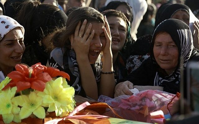 Illustrative: Women in the Kurdish-controlled city of Qamishly on August 13, 2016, mourn over a coffin during the funeral of several fighters from an Arab-Kurdish alliance, who were killed during battles with the Islamic State group (IS) in the northern Syrian city of Manbij. (AFP/Delil Souleiman)
