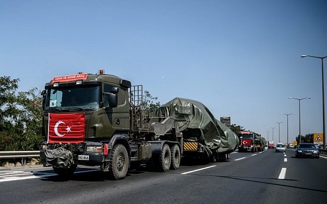 Military trucks with the Turkish national flag transport tanks as they drive on a highway out of Istanbul on August 22, 2016. (AFP/OZAN KOSE)