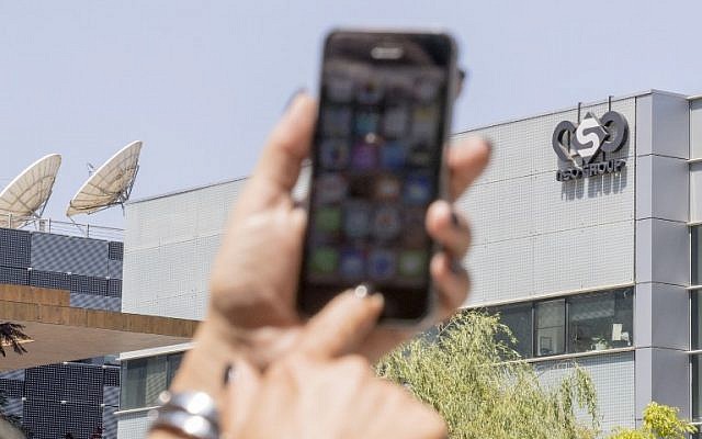 An Israeli woman uses her iPhone in front of the building housing the Israeli NSO group, on August 28, 2016, in Herzliya, near Tel Aviv. (AFP PHOTO / JACK GUEZ)