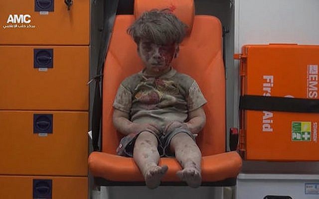 In this frame grab taken from video provided by the Syrian anti-government activist group Aleppo Media Center (AMC), 5-year-old Omran Daqneesh sits in an ambulance after being pulled out or a building hit by an airstirke, in Aleppo, Syria, Wednesday, Aug. 17, 2016. (Aleppo Media Center via AP)