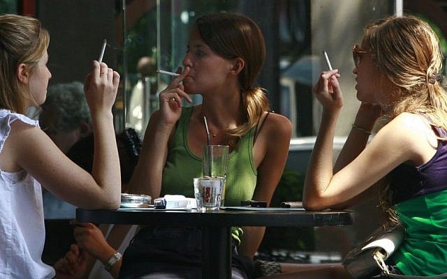 Israeli women smoke cigarettes while spending time at a cafe in central Tel Aviv. (Kobi Gideon / FLASH90)