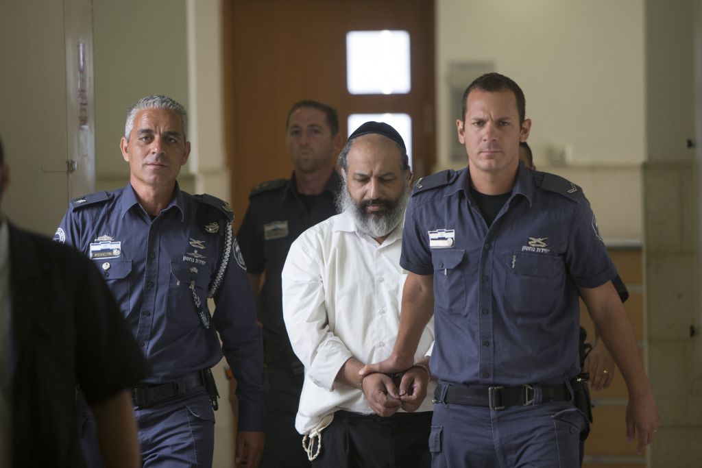 Alon Shamir, a 50-year-old therapist accused of raping two of his patients, is escorted by prison service guards at the District court as he arrives for a court hearing in Jerusalem on August 7, 2016, (Yonatan Sindel/Flash90)