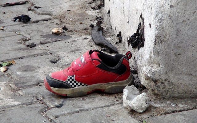 The shoe of a young victim and a piece of metal lay near the scene just hours after Saturday's bomb attack in Gaziantep, southeastern Turkey, early Sunday, Aug. 21, 2016, targeting an outdoor wedding party in southeastern Turkey killing dozens of people and wounding dozens more. (IHA via AP)