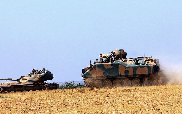 A Turkish army tank and an armored vehicle are stationed near the border with Syria, in Karkamis, Turkey, Tuesday, Aug. 23, 2016. (IHA via AP)