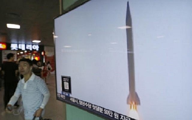 A man passes by a TV news program with  file footage of a North Korean rocket launch at the Seoul Railway Station in Seoul, South Korea, Wednesday, Aug. 3, 2016. (AP Photo/Ahn Young-joon)