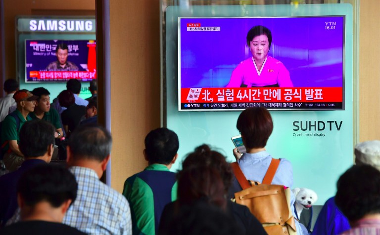 People watch a television news broadcast showing a North Korean anchor announcing the country's latest nuclear test, at a railway station in Seoul on September 9, 2016. (AFP Jung Yeon-Je)