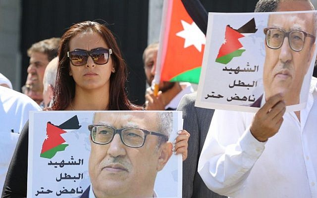 Protesters hold portraits of prominent Jordanian writer Nahed Hattar, who was shot dead the previous day outside an Amman court, during a demonstration in front of the prime minister's offices on September 26, 2016. (AFP PHOTO / Khalil MAZRAAWI)