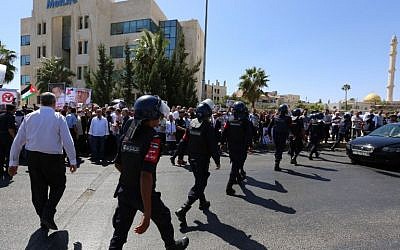 Jordanian police prevent activists and relatives of prominent Jordanian writer Nahed Hattar from blocking a street during a demonstration in front of the prime minister's offices in the Jordanian capital on September 26, 2016. (AFP PHOTO / Khalil MAZRAAWI)