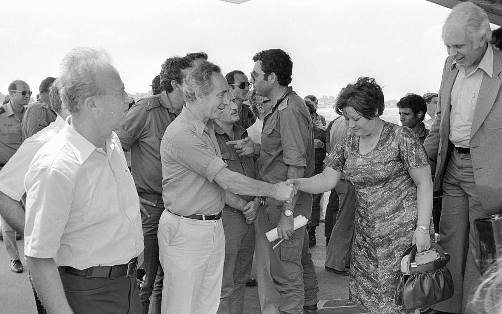 Then-defense minister Shimon Peres (c), along with former prime minister Yitzhak Rabin (l), meets the hostages released from Entebbe as they land in Israel on July 4, 1976. (Uri Herzl Tzchik/IDF Spokesperson's Unit/Defense Ministry Archives)