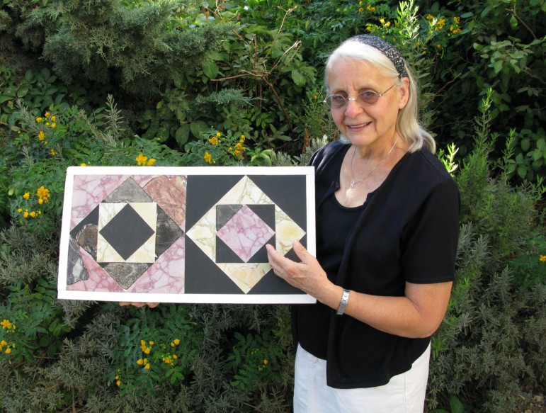 Frankie Snyder holds restored marble floor tiles based on fragments found in fill from the Temple Mount that archaeologists from the Temple Mount Sifting Project say are from the Herodian Temple in Jerusalem. (Temple Mount Sifting Project)