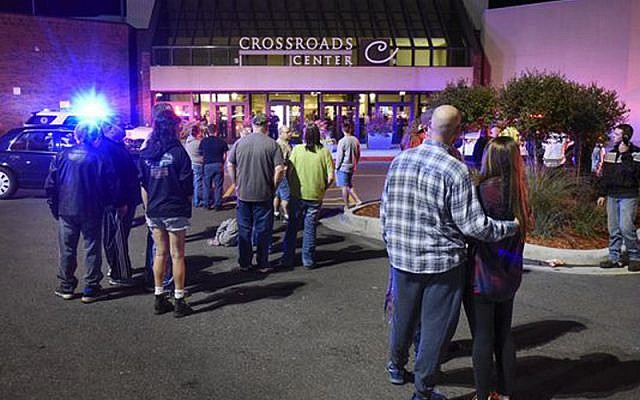 People stand near the entrance on the north side of Crossroads Center mall between Macy's and Target as officials investigate a reported multiple stabbing incident, September 17, 2016, in St. Cloud, Minnesota. (Dave Schwarz/St. Cloud Times via AP)