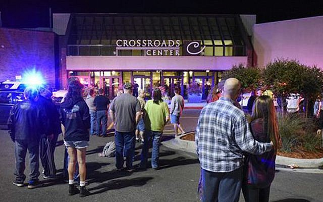 People stand near the entrance on the north side of Crossroads Center mall between Macy's and Target as officials investigate a reported multiple stabbing incident, Saturday, Sept. 17, 2016, in St. Cloud, Minnesota. (Dave Schwarz/St. Cloud Times via AP)