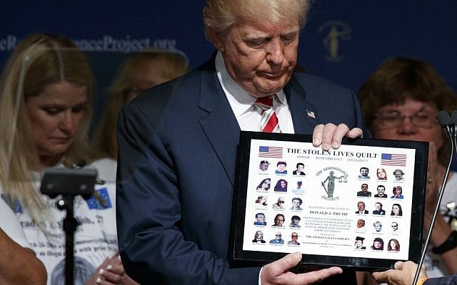 Republican presidential candidate Donald Trump is presented with a gift during an event with The Remembrance Project, Saturday, Sept. 17, 2016, in Houston, Texas. (AP Photo/Evan Vucci)