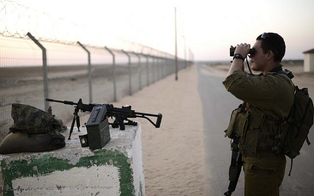Illustrative. An IDF soldier from the 10th division looks through binoculars into Gaza from a nearby Israeli community on August 7, 2014. (Tomer Neuberg/Flash90)