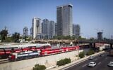 An Israel Railways train passes the Ayalon Highway, near the Arlozorov Street 'Central' train station in Tel Aviv, August 23, 2016. (Miriam Alster/Flash90)