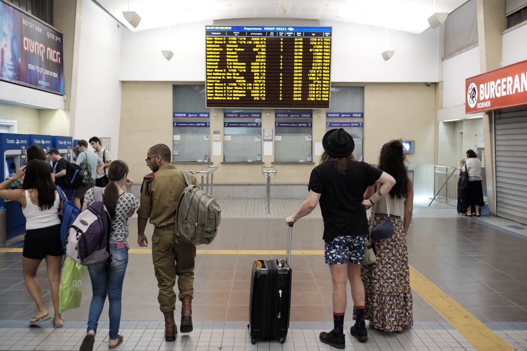 Travelers at central Tel Aviv's central Savidor station checking a schedule, where no trains northbound are listed, on September 3, 2016. (Tomer Neuberg/Flash90)