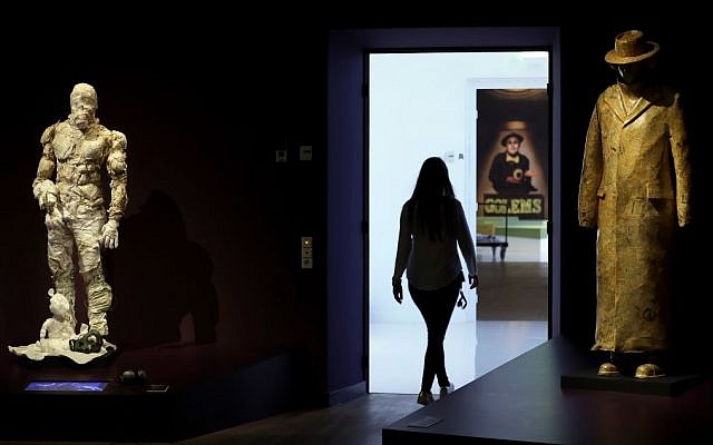 A woman walks past a Golem costume of the Malenki Theater in Tel Aviv, left, and a Golem sculpture of the Schaubuehne Theatre in Berlin for 'Death, Destruction and Detroit II', right, during a press presentation for the 'Golem' exhibition at the Jewish Museum in Berlin, Germany, Thursday, Sept. 22, 2016. (AP Photo/Michael Sohn)