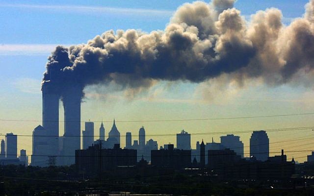 In this September 11, 2001 file photo, as seen from the New Jersey Turnpike near Kearny, New Jersey, smoke billows from the twin towers of the World Trade Center in New York after airplanes flown by Al-Qaeda terrorists crashed into both towers. (AP Photo/Gene Boyars, File)