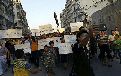 In this Sept. 13, 2016 file photo provided by Modar Shekho, activists in Syria's besieged Aleppo protest against the United Nations for what they say is its failure to lift the siege off their rebel-held area, in Aleppo, Syria. (Modar Shekho via AP, File)
