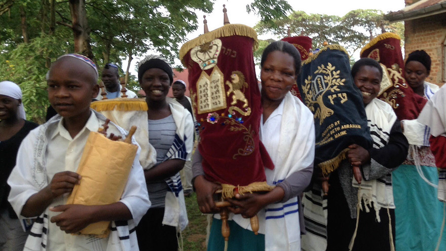 Jewish community members in Nabagoye, Uganda, with the Torah. (Courtesy of Be’chol Lashon via JTA)